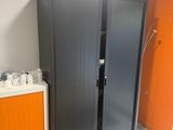cabinets in a room with orange walls and a blue rug