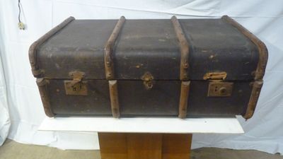 an old suitcase sitting on top of a wooden stand