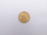 a close up of a gold coin on a white surface
