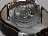 a close up of a watch on a white surface
