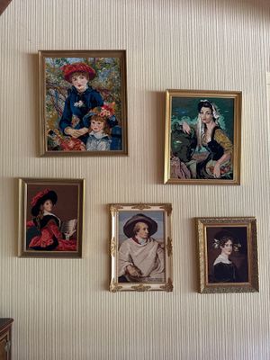 quatre tableaux accrochés au mur d'une pièce où sont accrochés des tableaux