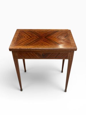 une petite table en bois dont le plateau présente un motif en chevrons