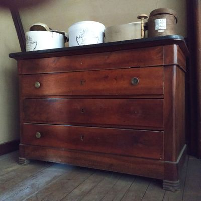 une commode en bois sur laquelle sont posées trois tasses