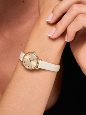 La femme porte une montre blanche et un bracelet blanc.