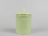 an image of a green ceramic jar with a lid on a gray surface