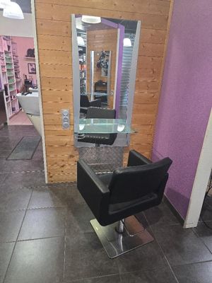 une chaise noire placée devant un miroir dans un salon