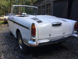 a white car parked in front of a barn