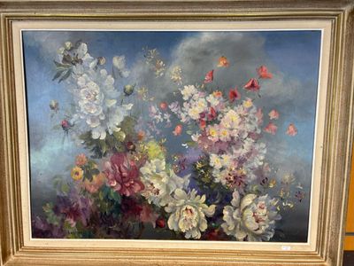 un tableau représentant des fleurs, dans un cadre doré, posé sur une table