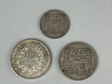 three silver coins sitting next to each other on a white surface