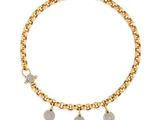 a close up of a gold chain bracelet with three charms