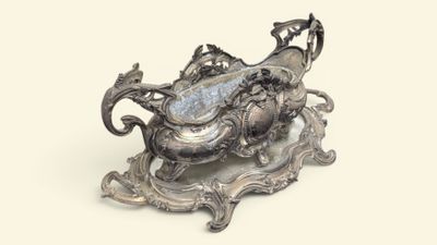 un plateau en argent orné d'un dragon, posé sur un socle