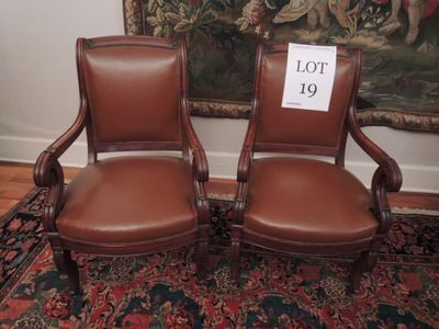 deux chaises en cuir marron posées sur un tapis devant un tableau