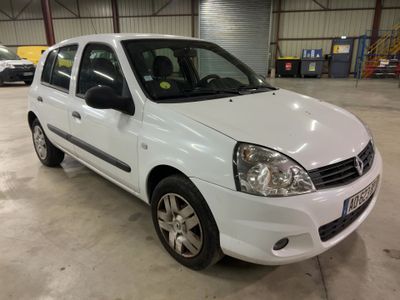 La petite voiture blanche est garée dans un grand garage.