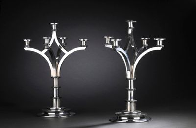 pair of silver candlesticks on a black background
