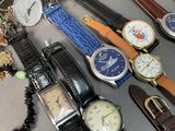 many different types of watches and bracelets laid out on a table
