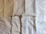 de nombreux types de linge de lit blanc sur un lit