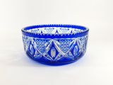 a blue glass bowl sitting on top of a white table