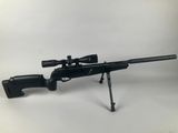 a rifle with a scope on a tripod on a white background