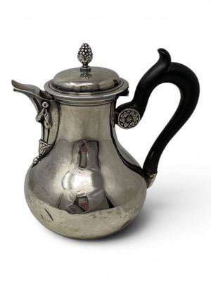 a silver teapot with a black handle on a white background