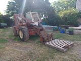 un tracteur garé dans l'herbe avec une palette