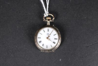 une petite montre de poche en argent avec une chaîne, posée sur une surface noire