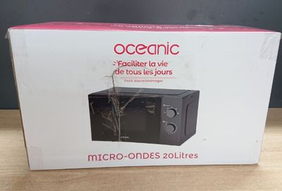 emballage d'un micro-ondes posé sur une table, d'où sort une plante