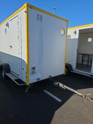 une remorque blanche aux finitions jaunes, garée sur un parking