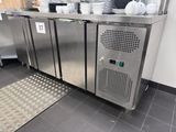 un plan de travail en inox sur lequel sont posés tout un tas de plats