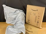 two bags of food sitting on the floor next to a cardboard box