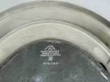 a silver plate with a picture on it on the wall