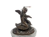 statue of a woman sitting on a turtle with a frisbee in her hand
