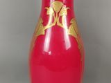 un vase rouge orné d'un motif doré