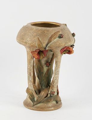 a small vase with flowers on it on a white surface