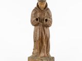wooden statue of a monk holding a pipe on a white background