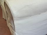 a white couch with pillows on top of it in a room