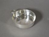 un bol en argent avec une cuillère sur une table