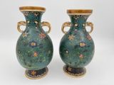 une paire de vases ornés de motifs floraux sur un fond blanc