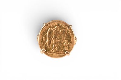a close up of a gold coin on a white surface