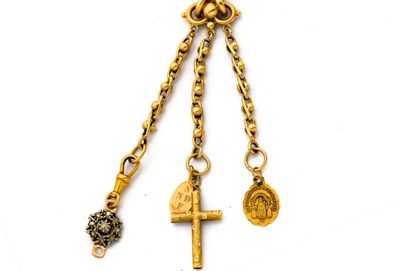 une chaîne en or à laquelle sont suspendus une croix et une pièce de monnaie