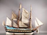 une maquette de voilier exposée sur une surface grise