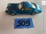 une petite voiture posée à côté d'une feuille de papier