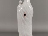 white ceramic figurine of a hand holding a bird on a branch