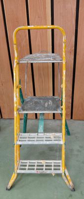 un tabouret jaune et vert posé sur un sol vert