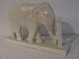 statue of a man standing next to an elephant on a white surface