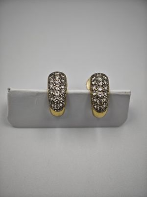 une paire de boucles d'oreilles en or et diamants sur fond blanc