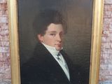 portrait d'un jeune homme en smoking devant un mur de briques