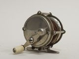 a small fishing reel with a wooden handle on a white surface