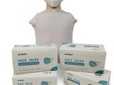 trois boîtes de masques faciaux et une tête de mannequin sur fond blanc