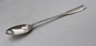 une cuillère en argent posée sur une surface blanche, avec une petite cuillère au milieu