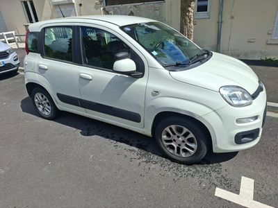une petite voiture blanche garée sur le bord de la route